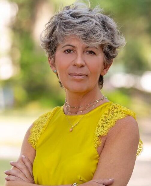 Elena Di Stefano – SEO Impact Pros Elena Di Stefano, Head of Content Strategy, wearing a yellow top in outdoor portrait