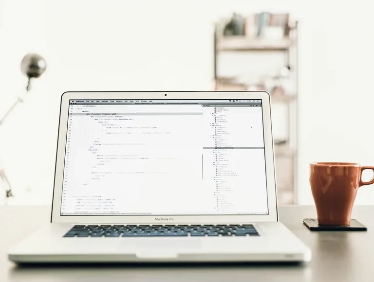 Laptop on a desk showing code in an editor