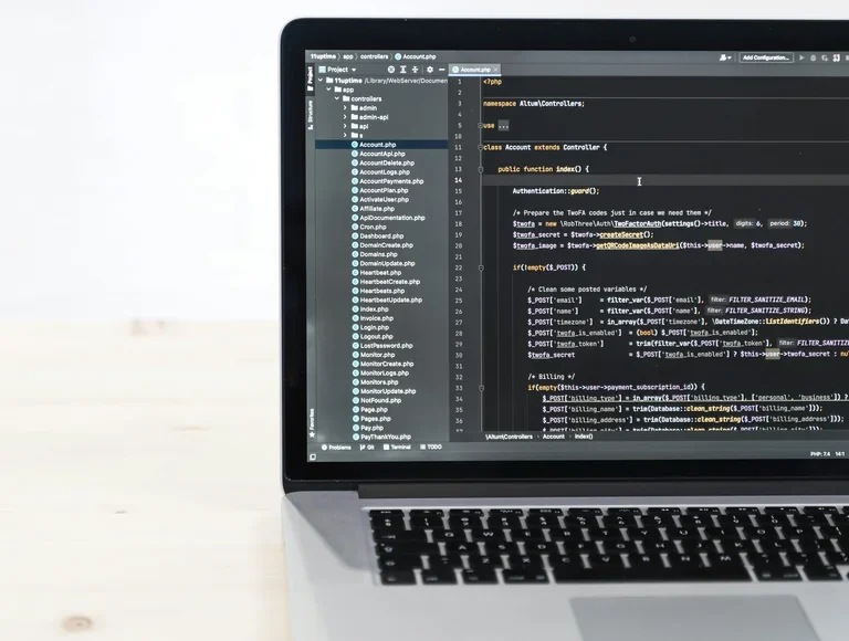 Code editor open on a laptop showing site files and PHP